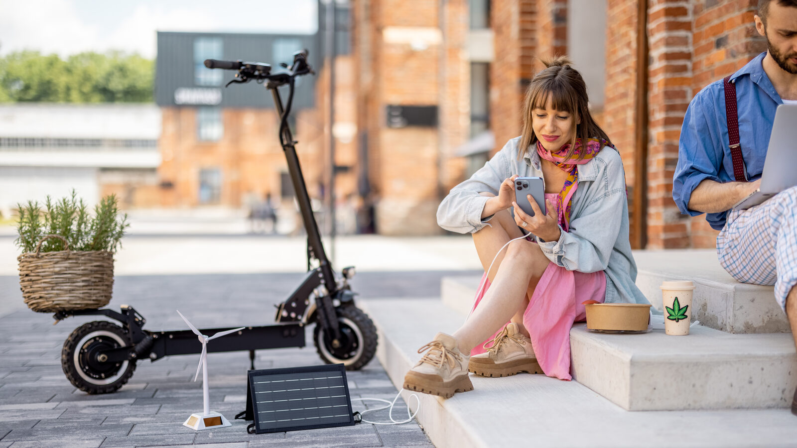 Young adults relaxing near a parked electric scooter