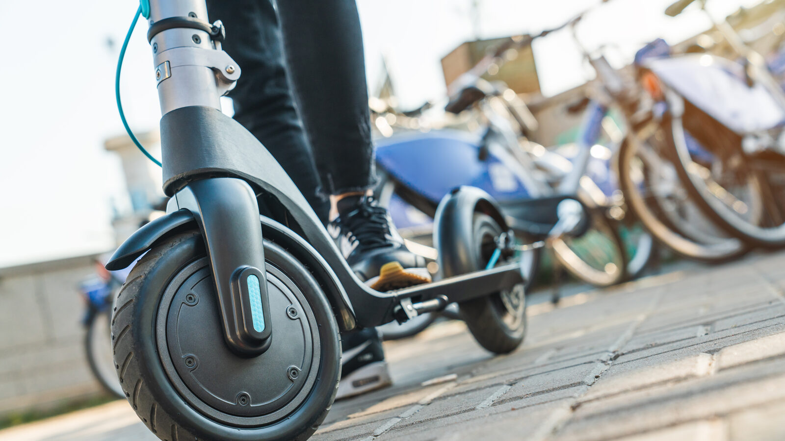 Close-up of a rider's feet standing on an electric scooter deck