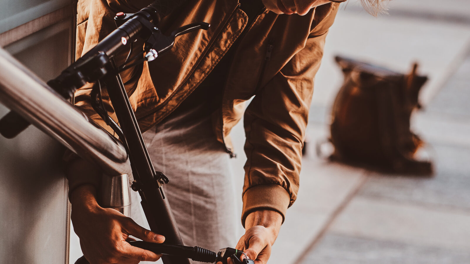 A rider locking up an electric scooter in an urban area