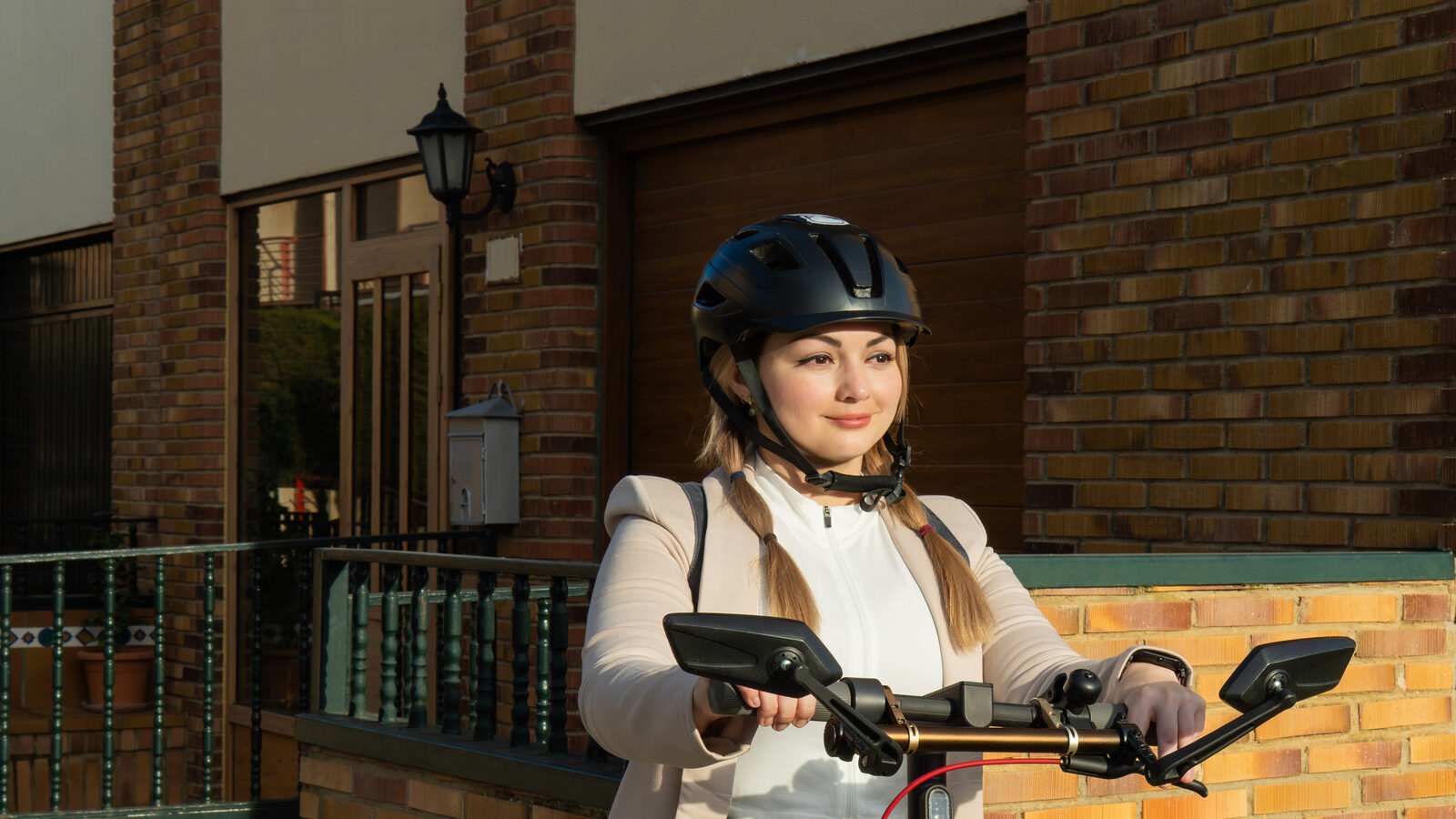 Woman wearing a helmet commuting on an electric scooter on an urban street